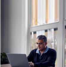 man sitting at the kitchen table with his laptop